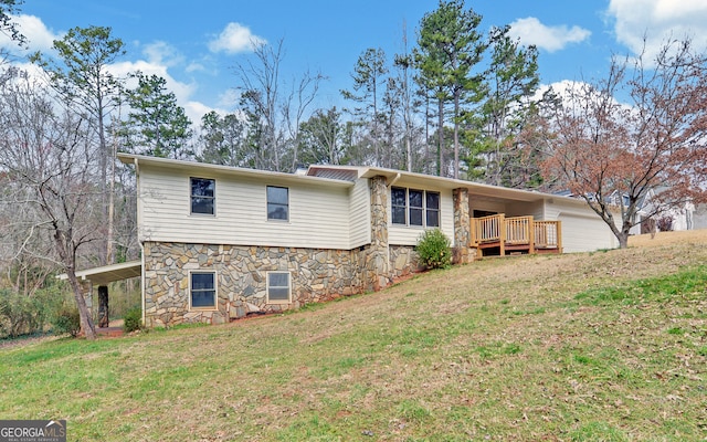 back of house featuring stone siding and a lawn