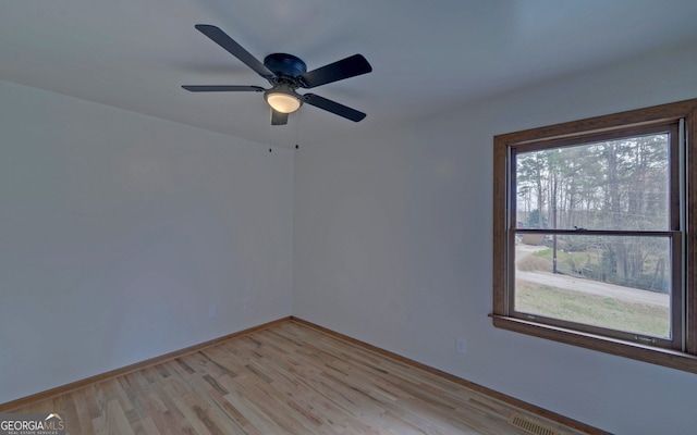 unfurnished room featuring light wood-type flooring, visible vents, and baseboards