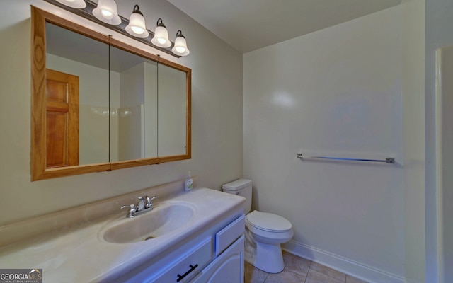 bathroom featuring toilet, tile patterned floors, baseboards, and vanity