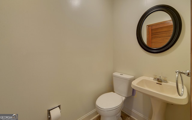 bathroom with toilet and baseboards