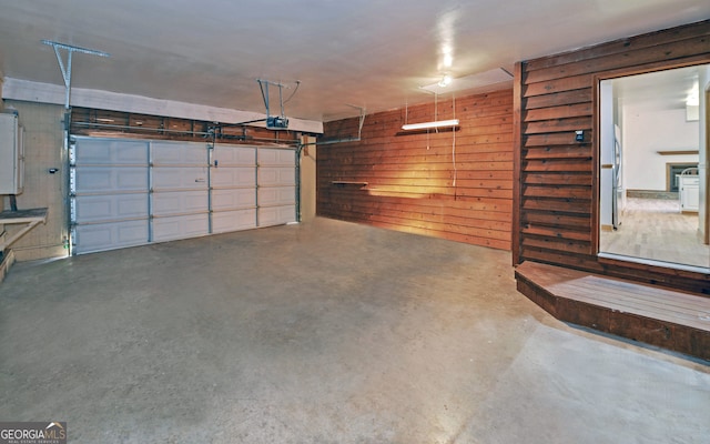 garage with a garage door opener and wooden walls