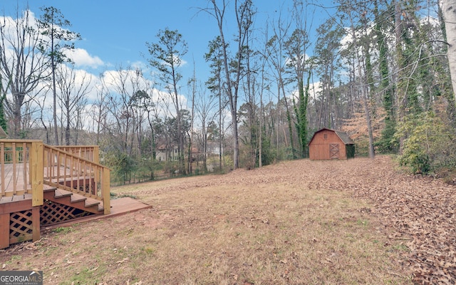 view of yard with a shed, a wooden deck, and an outdoor structure