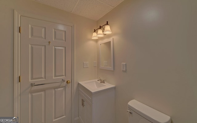 bathroom featuring toilet, a paneled ceiling, and vanity