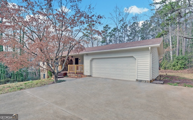 view of front facade featuring driveway, covered porch, and a garage