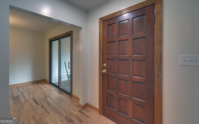 foyer with light wood-style floors and baseboards