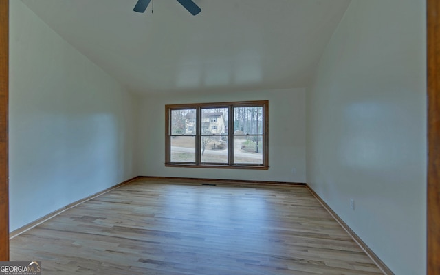 empty room with lofted ceiling, baseboards, a ceiling fan, and wood finished floors