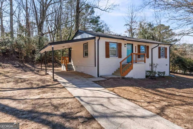 view of front of property with driveway, an attached carport, and brick siding