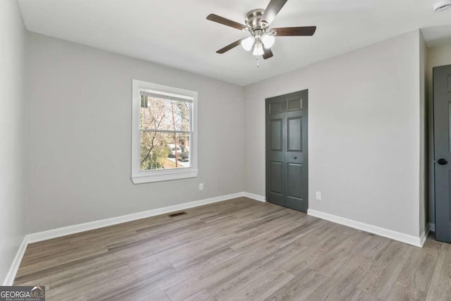 unfurnished bedroom with a ceiling fan, baseboards, and wood finished floors