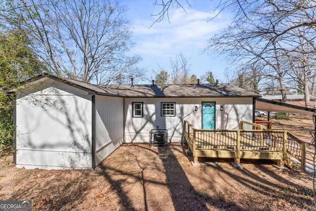 back of house featuring a wooden deck and central AC unit