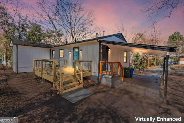 view of front of property with a carport, driveway, and a wooden deck