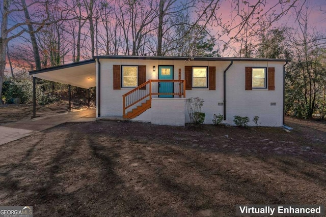 view of front of home featuring a carport, concrete driveway, and brick siding