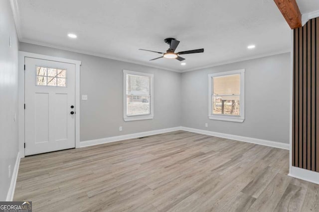 foyer featuring light wood-style floors, crown molding, and a wealth of natural light