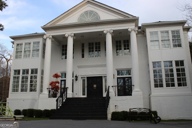 greek revival inspired property featuring brick siding