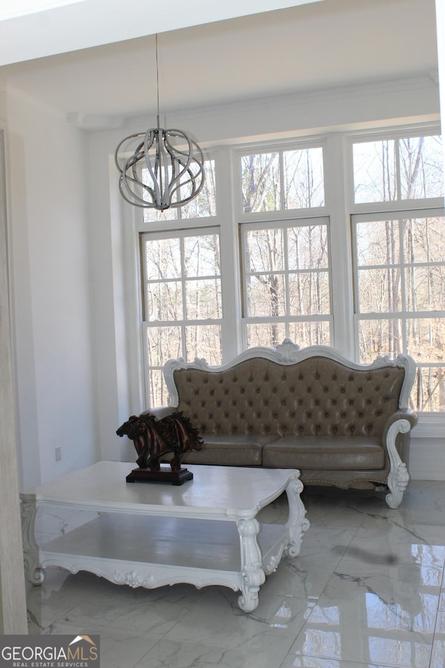 living room featuring a notable chandelier, marble finish floor, and a healthy amount of sunlight