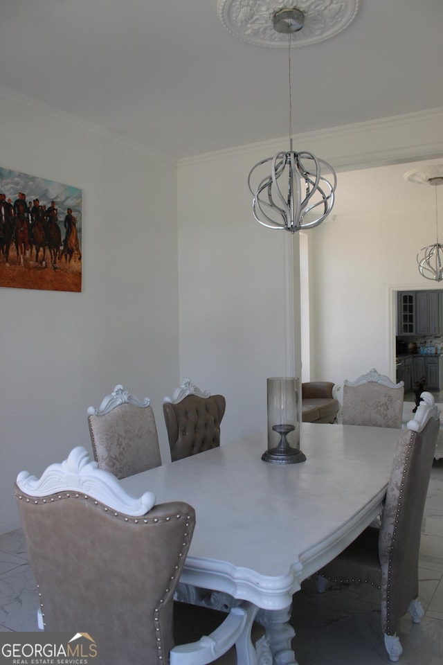 dining space featuring crown molding, a notable chandelier, and marble finish floor