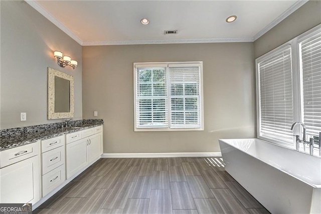 full bath with visible vents, baseboards, a soaking tub, and crown molding