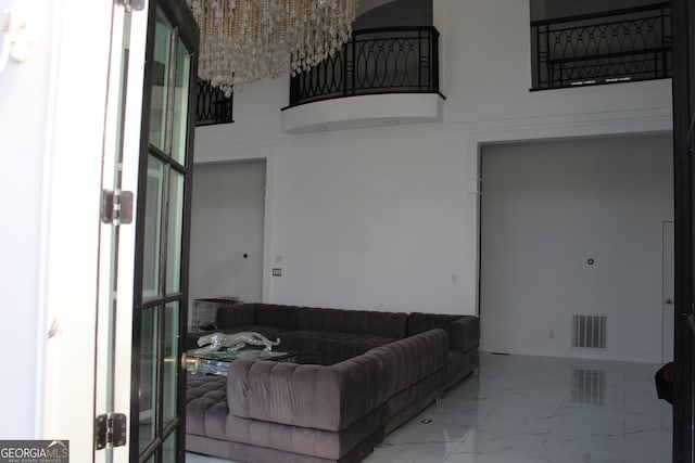 living room with visible vents, marble finish floor, and a high ceiling