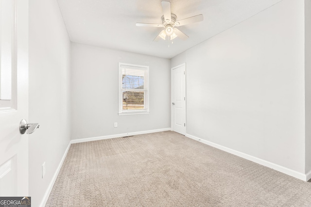 carpeted empty room featuring ceiling fan and baseboards