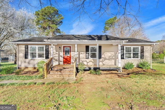 ranch-style house with a front yard and covered porch