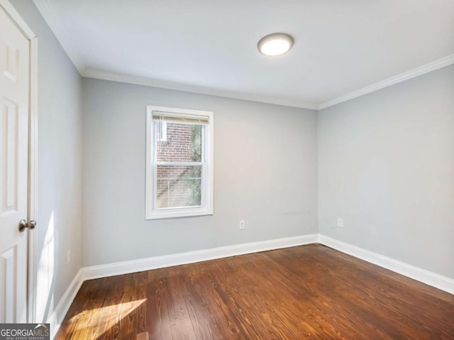 unfurnished room featuring dark wood-style floors, crown molding, and baseboards