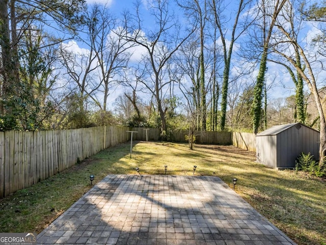 view of yard featuring a patio area, a fenced backyard, a storage unit, and an outdoor structure