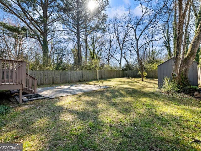 view of yard with an outbuilding, a patio, a shed, and a fenced backyard