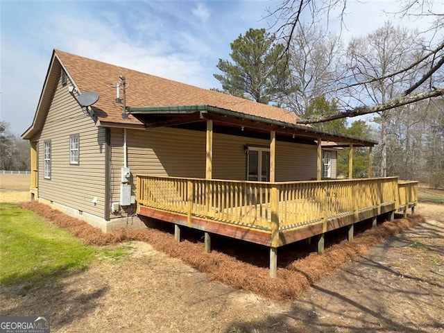 rear view of property with crawl space and roof with shingles