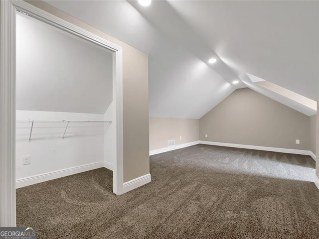 bonus room with lofted ceiling, carpet flooring, visible vents, and baseboards