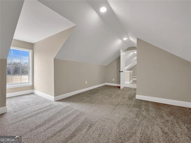 additional living space with carpet, baseboards, and vaulted ceiling