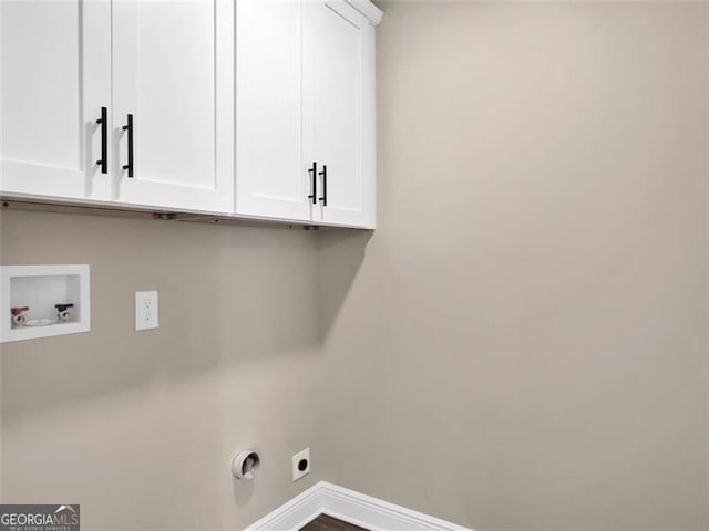 washroom featuring electric dryer hookup, washer hookup, cabinet space, and baseboards