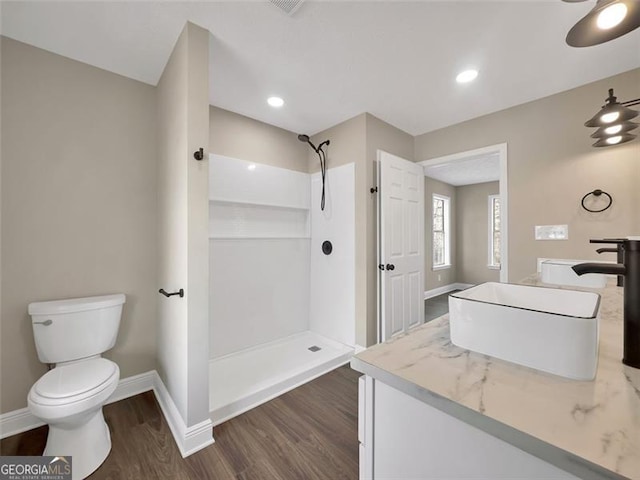 full bathroom featuring toilet, baseboards, a shower, and wood finished floors