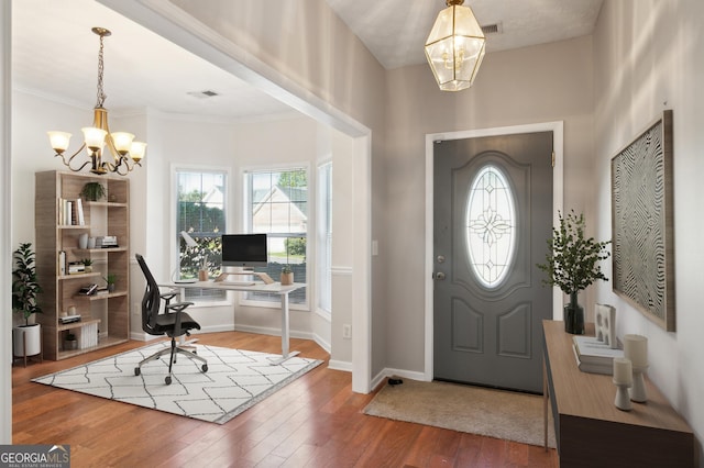 foyer with a wealth of natural light, a chandelier, and hardwood / wood-style floors