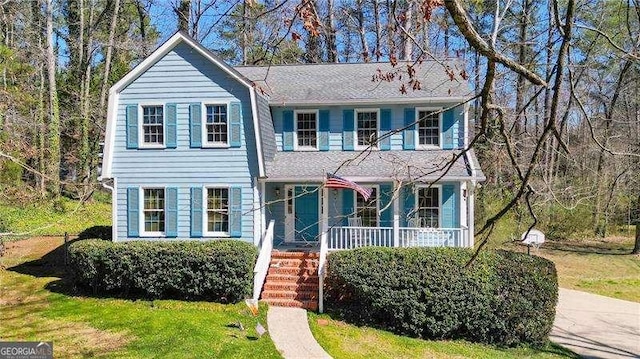 view of front of home with a porch and a front yard