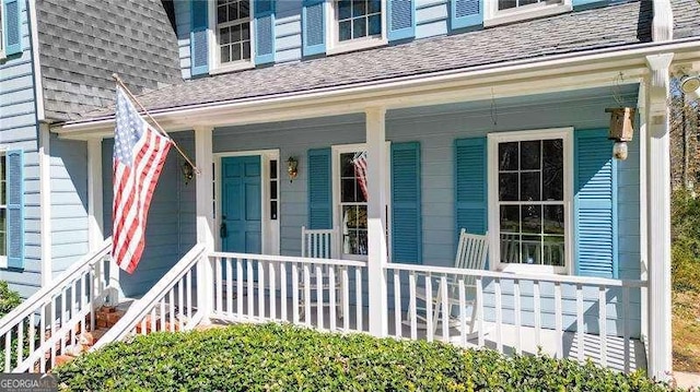 property entrance with a porch and roof with shingles