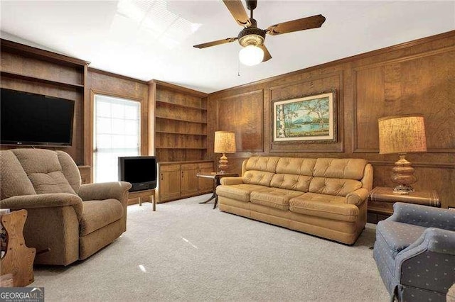 living room featuring wood walls, built in features, and light colored carpet