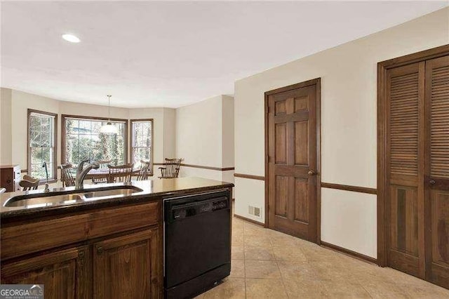 kitchen featuring black dishwasher, hanging light fixtures, light tile patterned flooring, a sink, and baseboards