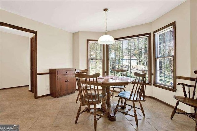 dining space featuring light tile patterned floors and baseboards