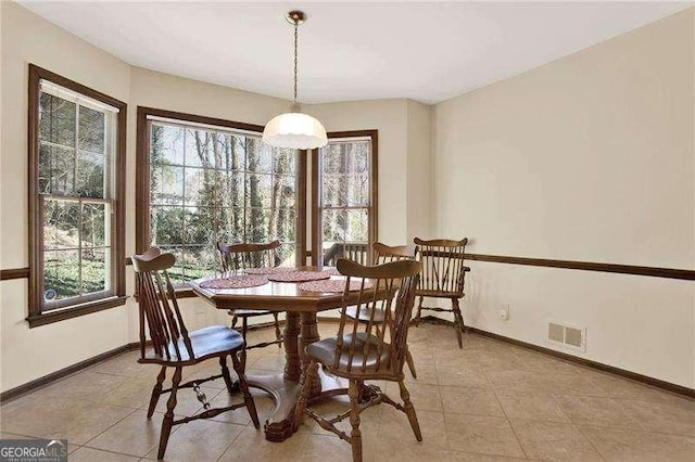 dining area featuring light tile patterned floors, visible vents, and baseboards