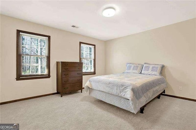 carpeted bedroom featuring visible vents and baseboards