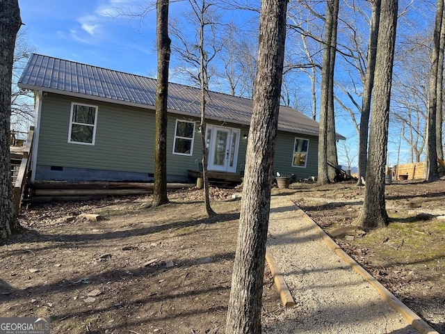 view of front of house with metal roof, french doors, and crawl space