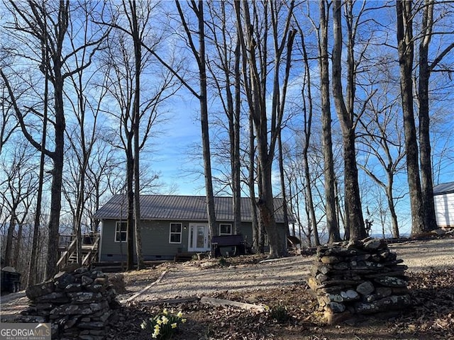 view of front of home featuring metal roof and crawl space