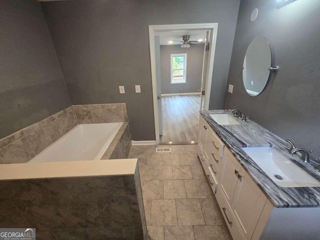 full bath featuring a tub, visible vents, a sink, and baseboards