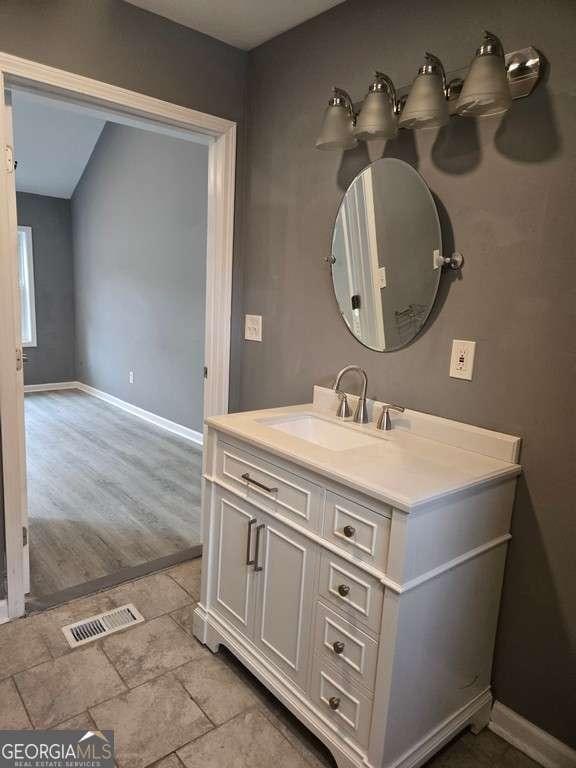 bathroom featuring baseboards, visible vents, and vanity