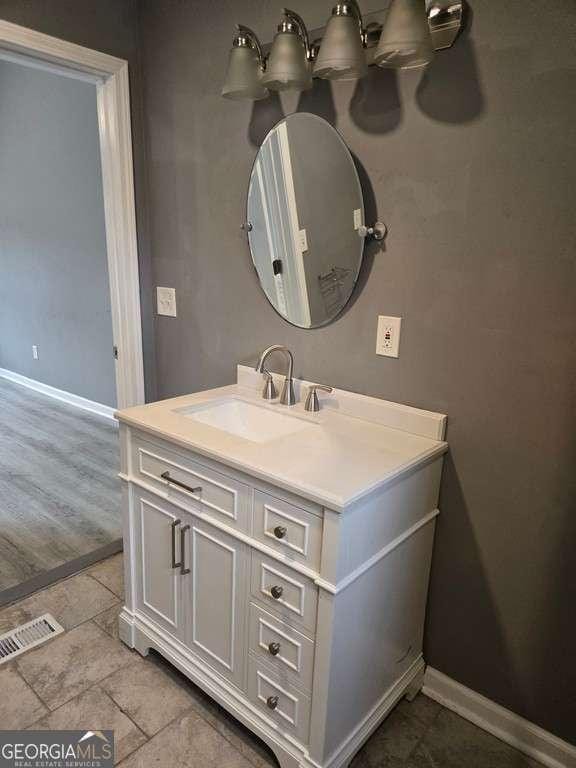 bathroom with baseboards, visible vents, and vanity