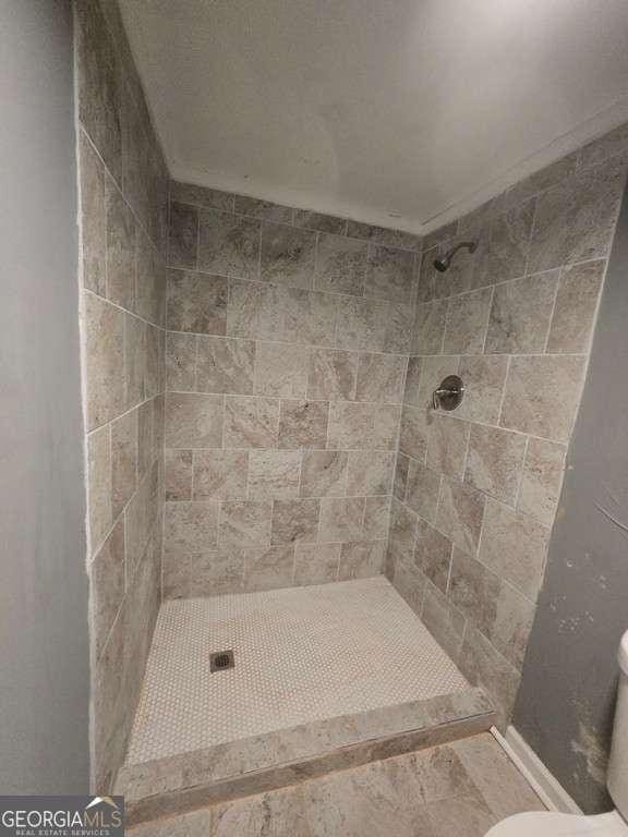 bathroom featuring toilet and a shower stall