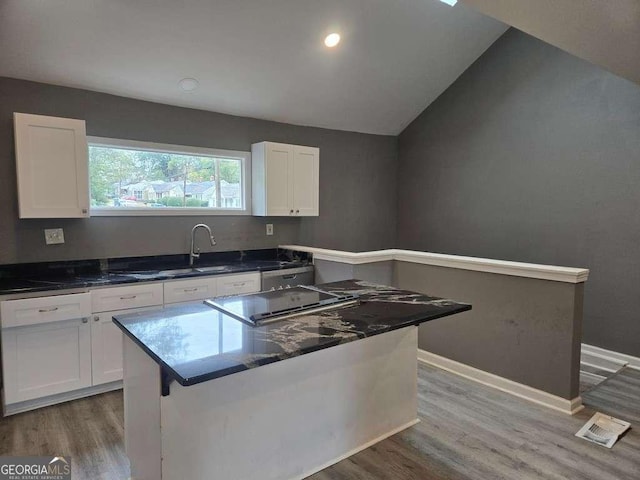 kitchen with baseboards, wood finished floors, and white cabinets