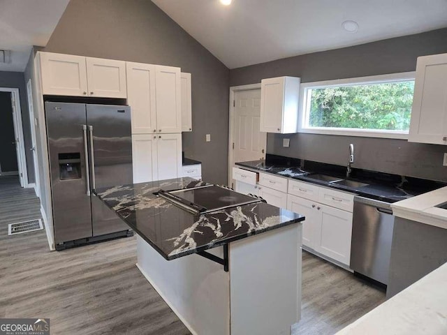 kitchen with stainless steel appliances, white cabinets, visible vents, and a sink