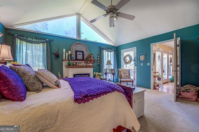 carpeted bedroom with a fireplace, high vaulted ceiling, and a ceiling fan