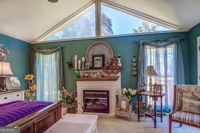 bedroom featuring carpet, a glass covered fireplace, and vaulted ceiling