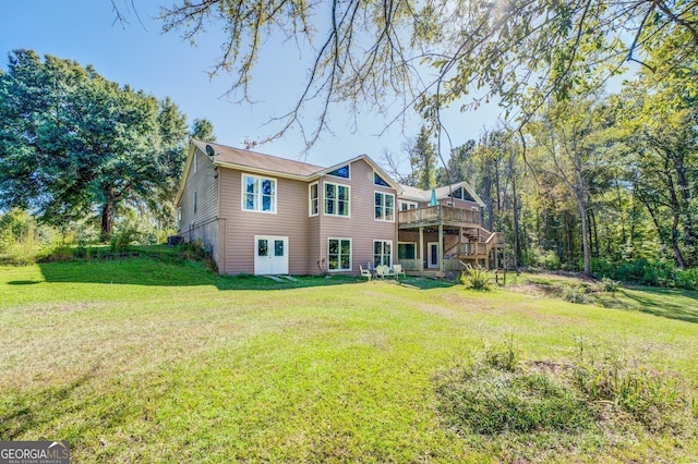 rear view of house with a yard, a deck, and stairs